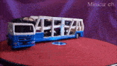 a blue and white toy truck is sitting on a red surface with the words minicar ch written on the bottom