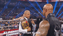 a man in a wrestling ring is talking into a microphone and says go fuck yourself