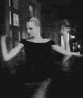 a blurry black and white photo of a person standing in a dark room