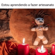 a voodoo doll is sitting on a wooden table with candles .