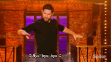 a man is dancing in front of a brick wall and saying bye bye bye