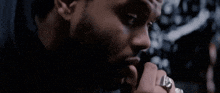 a man with a beard is singing into a microphone while wearing a ring .