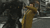 a man in a yellow suit is being attacked by a robot
