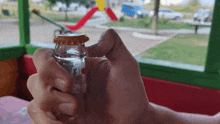 a person is opening a coca cola bottle in front of a window
