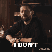 a man sitting at a table with the words i don 't on his face