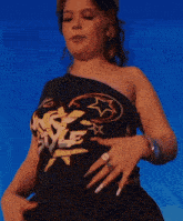 a woman wearing a one shoulder top that says nk style