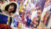 a woman in a white hat is standing in front of a painting of a woman in a belly dance costume .