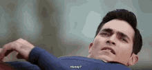 a man in a superman costume is laying on the ground and asking honey .