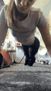 a woman is doing push ups on the floor in a living room .