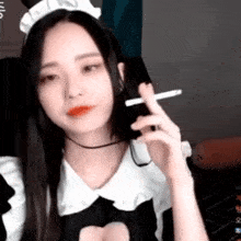 a woman in a maid costume is smoking a cigarette on a webcam .