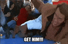 a man is laying on the ground with a group of people surrounding him and the words get him written on the bottom