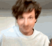 a close up of a man making a funny face while wearing a white shirt .
