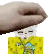 a hand is holding a spongebob squarepants sticker over a furry cat .