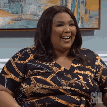 a woman wearing a snl shirt is smiling