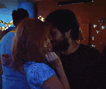 a man and a woman are dancing together in a dark room with lights on the wall .