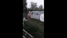 a man is sitting in a hot tub outside of a house .