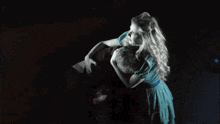 a man and a woman are hugging in a dark room .