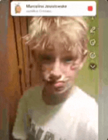 a young boy is making a funny face while wearing a white t-shirt .
