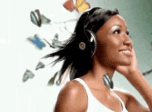 a woman is wearing headphones and smiling while listening to music .