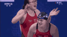 a group of female swimmers are standing next to each other in a swimming pool .