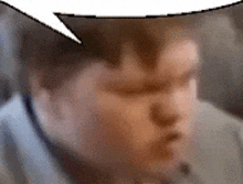 a blurry picture of a man 's face with a speech bubble above his head .