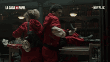 a man in a red jacket from la casa de papel holds a book
