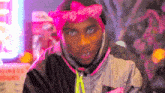 a man wearing a pink bandana and a pink jacket
