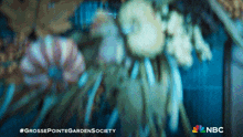 a blurry picture of flowers with the words grossepointegardensociety