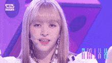 a close up of a woman 's face with a microphone in front of a sign that says kpop