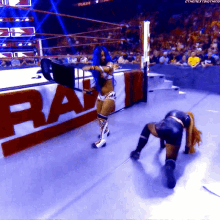 a woman in a wrestling ring with the word raw on the side