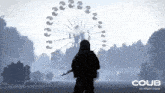 a silhouette of a man standing in front of a ferris wheel that says coub on the bottom