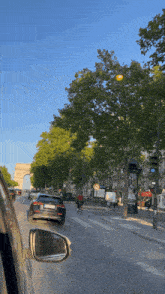 a car is driving down a street with trees and a sign that says " no parking "