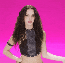 a woman with curly hair is wearing a black top with a fur trim