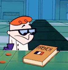 a cartoon character is sitting at a table next to a book titled french