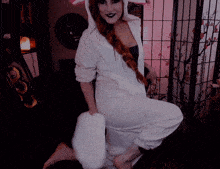 a woman in a unicorn costume is kneeling down in front of a floral screen