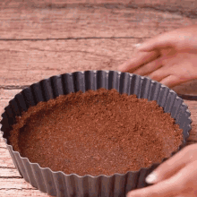 a person is making a pie crust in a metal pan