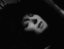 a close up of a woman 's face in a black and white photo