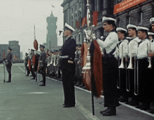 a group of men in military uniforms stand in front of a building with a red sign that says " a zeit in berlin "