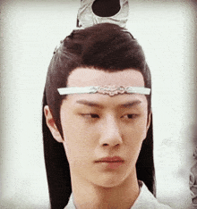 a close up of a man 's face with a white headband