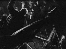 a black and white photo of a crowd of people playing violins