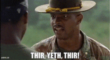 a man in a hat is talking to another man in a field .