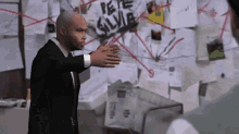 a man in a suit stands in front of a bulletin board that says pete silvia on it