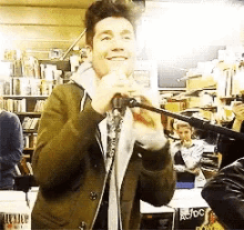 a man singing into a microphone in front of a sign that says joc
