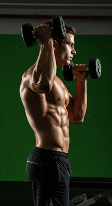 a shirtless man is lifting two dumbbells in front of a green screen