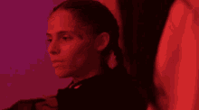 a close up of a woman 's face in a dark room with red lights .