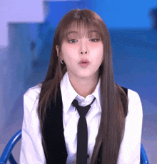 a woman with long hair wearing a white shirt and black tie