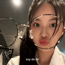 a woman wearing glasses with the word soy de bri on the bottom right