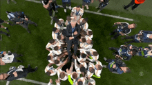 a group of soccer players are huddled around a man with the number 23 on his jersey