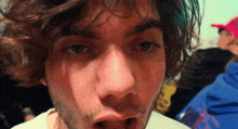 a close up of a man 's face with a beard and a white shirt that says ' supreme ' on it