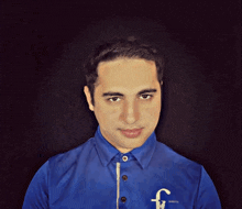 a man wearing a blue shirt with the letter f on the sleeve